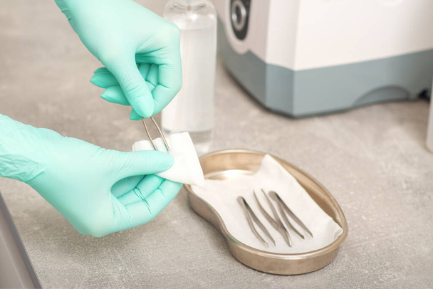 Hand desinfecteert pincet met reinigingssystemen voor medische instrumenten. Ultrasone reiniger - Foto, afbeelding