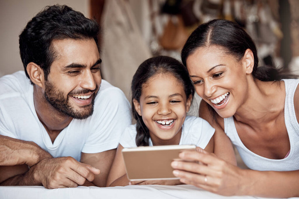 C'est une famille connectée. une famille heureuse utilisant un téléphone portable ensemble à la maison - Photo, image