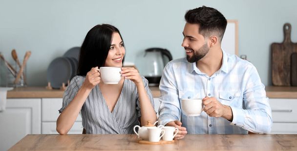 Glückliches junges Paar trinkt morgens zu Hause Tee - Foto, Bild