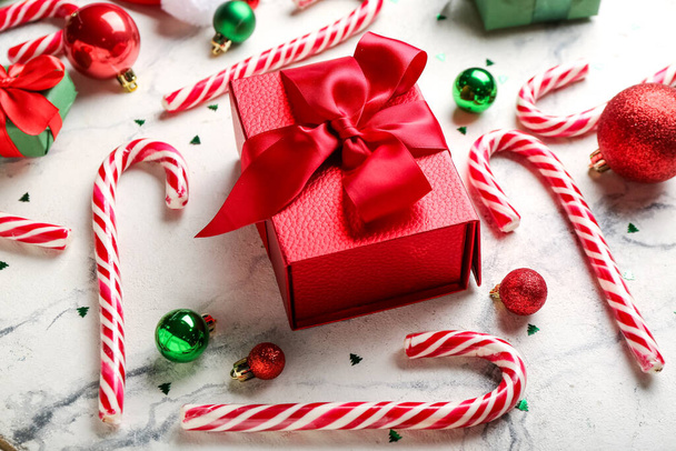 Рождественский подарок, сладкие конфеты трости и шары на светлом фоне - Фото, изображение