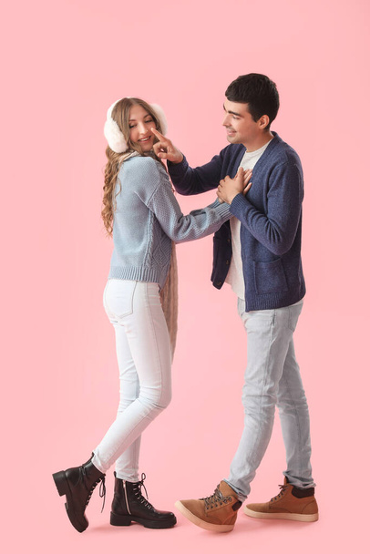 Mladý muž dotýká nos své milované přítelkyně na růžovém pozadí - Fotografie, Obrázek