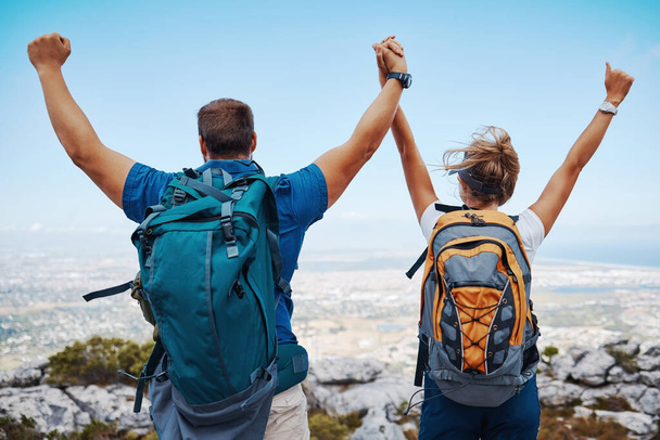 Success, hiking and couple holding hands on a mountain top in celebration with freedom and support outdoors. Nature, goals and healthy woman enjoys a lovely fitness milestone achievement with partner. - Foto, imagen