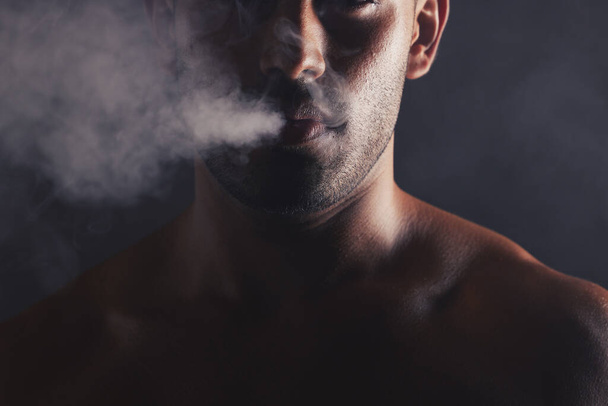 Smoke cloud, face and man in studio for addiction, smoker and bad habit on black studio background mockup. Tobacco, vape or marijuana with guy model pose with space for awareness, cancer and health. - Fotó, kép