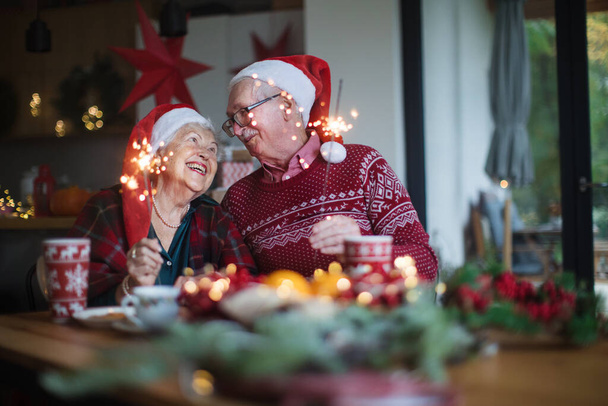 Happy senior couple celebrating New Year eve with sparklers. - Zdjęcie, obraz