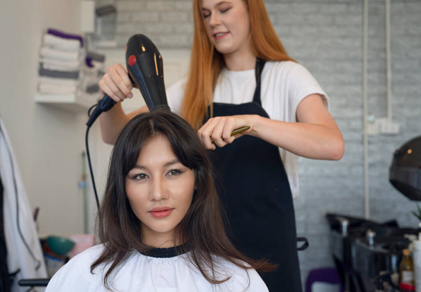 Europejska kobieta fryzjer w salonie piękności obciąć włosy i projekt włosów do jej klienta - Zdjęcie, obraz