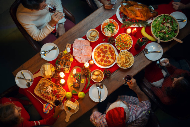 Tisch mit Truthahnbraten und Essen in Weihnachten und Neujahr Party der amerikanischen Familie zu Hause, Familienmitglieder genießen hausgemachte Truthahngrill-Essen im Haus versammeln - Foto, Bild