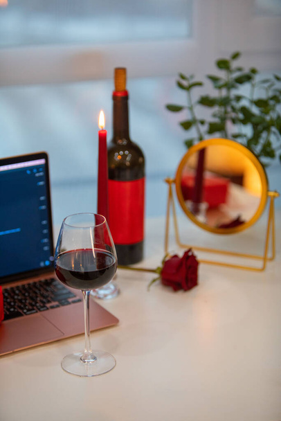 glass of wine with gift box in front of laptop online dating concept - Фото, изображение
