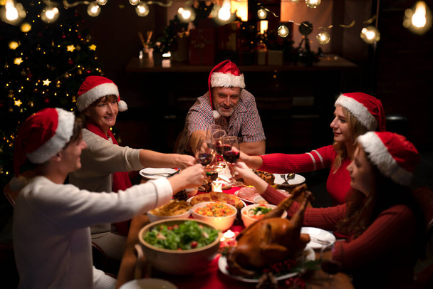 クリスマスのロースト七面鳥と食べ物のテーブルと自宅でアメリカの家族の新年パーティー、家族は家で作る七面鳥のグリルダイニングを楽しむ家に集まる - 写真・画像