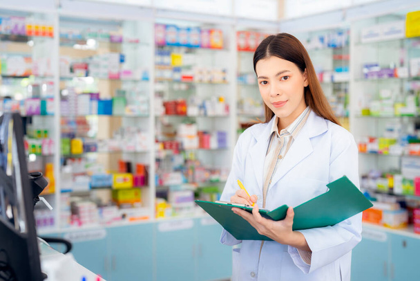 Ασιάτισσα φαρμακοποιός γυναίκα στο φαρμακείο κατάστημα της επιχείρησής της προς πώληση ένα φάρμακο και φαρμακείο - Φωτογραφία, εικόνα