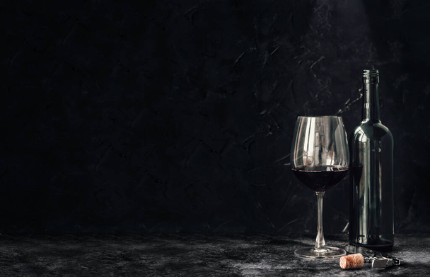 bottle red of wine with a glass on a black background - Foto, Imagen