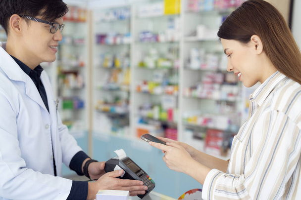 Asiatique fille paiement par scan qr code par son téléphone intelligent à la pharmacie dans un grand magasin - Photo, image