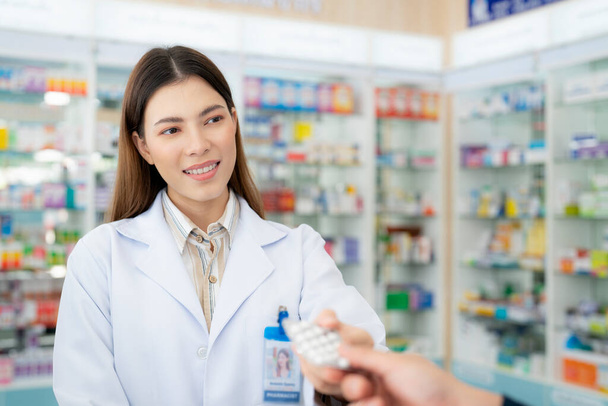 Asiatica farmacista donna in farmacia negozio della sua attività in vendita un farmaco e farmacia - Foto, immagini