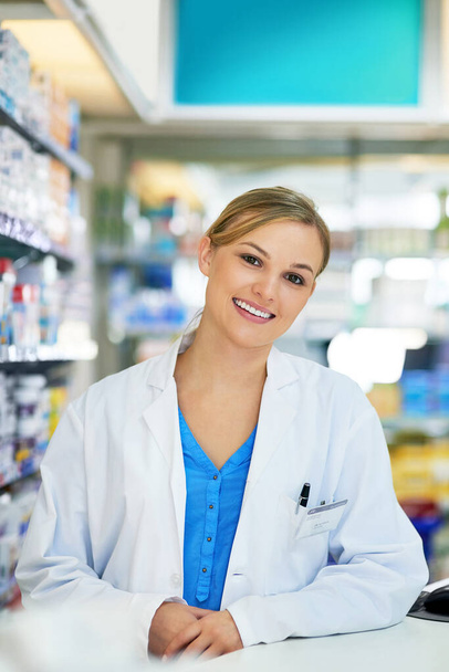 Consejos relacionados con la salud en los que puedes confiar. Retrato de una joven feliz trabajando en una farmacia - Foto, imagen