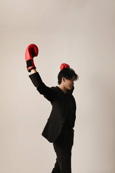 Zelfverzekerde jonge aziatische man met rode doos handschoenen poseren op de witte achtergrond. Geestelijke gezondheidsproblemen. Hoge kwaliteit foto. - Foto, afbeelding