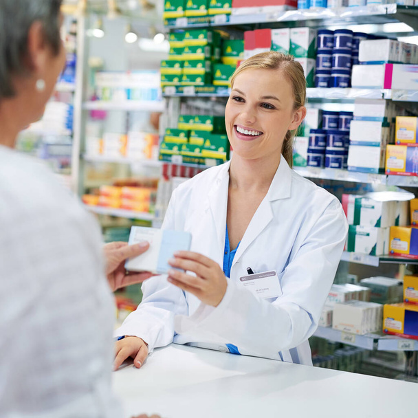 Is there anything else I can help with. a young pharmacist assisting a customer - Foto, afbeelding