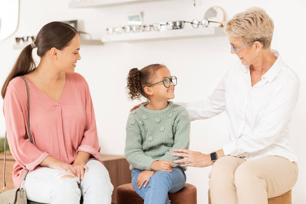 Optometry, glasses and vision with a girl, mother and optician meeting for an appointment or checkup in an optometrist office. Family, kids and eyewear with a woman and daughter at an ophthalmologist. - Foto, afbeelding