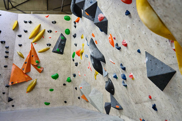 Wall for bouldering in gym with holds for climbing. Active extreme sport concept - 写真・画像