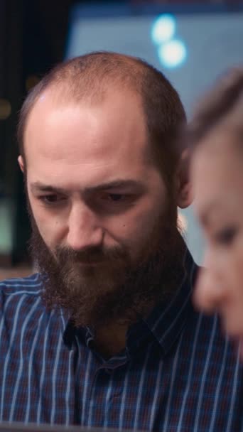 Vertical video: Employee looking at camera in business meeting, smiling, coworkers talking in boardroom, slow motion. Colleagues brainstorming, company worker in coworking space portrait close up - Footage, Video