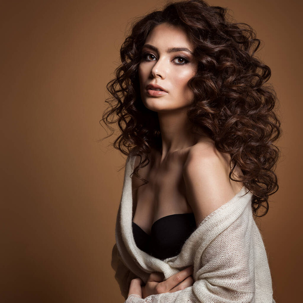 Woman Curly Wavy Long Hair. Fashion Model Volume Curls Hairstyle over brown Background. Brunette Girl Portrait with Natural Makeup and Italian Haircut - Фото, изображение