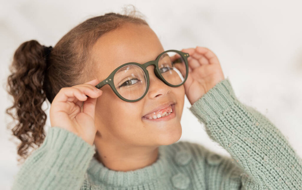 Face portrait, child and girl with glasses for optical health at optometrist office. Eyes wellness, eye care and happy kid with specs, spectacles or prescription lenses to help with ocular vision - Photo, Image