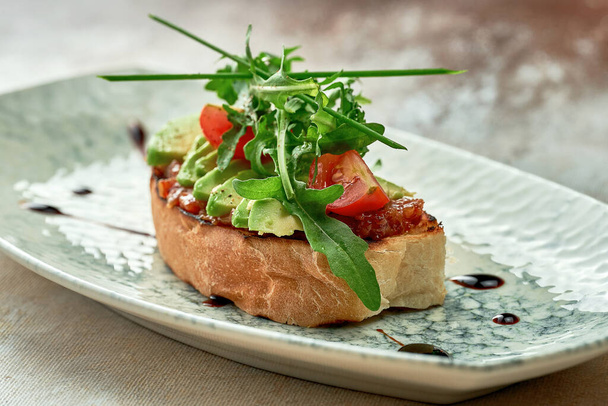 Bruschetta with avocado and onion confit. Close-up, selective focus - 写真・画像