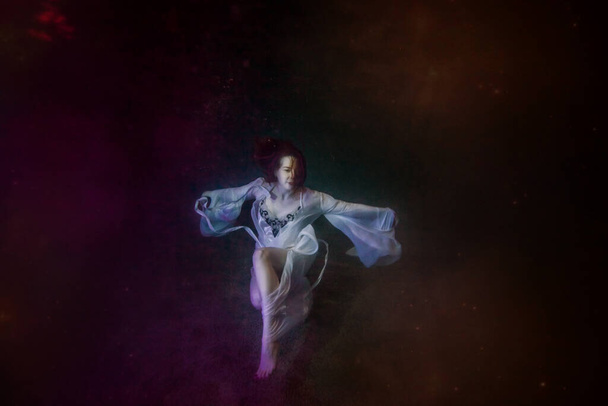 Pintura subacuática abstracta de una niña vestida con un vestido blanco bajo el agua. - Foto, imagen