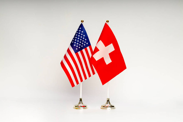 Az USA és Svájc állami zászlói könnyű háttérrel. Zászlók. - Fotó, kép