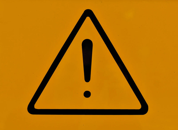 Triángulo con signo de exclamación en el centro sobre fondo naranja. Peligro, exclamación, señal de advertencia - Foto, Imagen