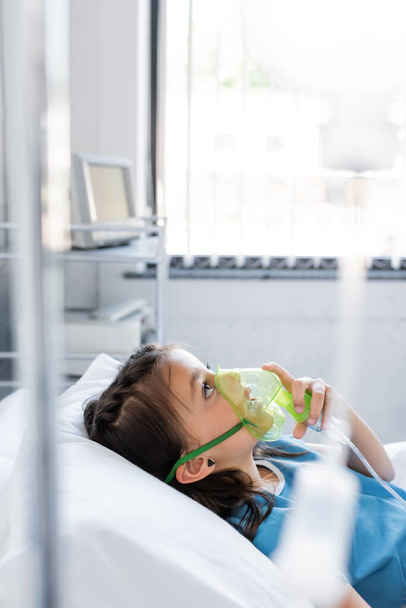 Kind met zuurstofmasker op bed op ziekenhuisafdeling  - Foto, afbeelding