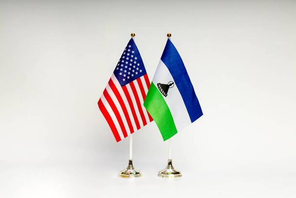 Állami zászlók az USA és Lesotho a könnyű háttér. Zászlók. - Fotó, kép