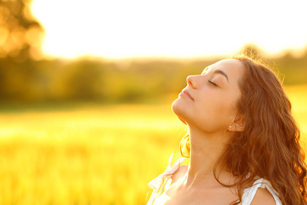 Relaxed woman breathing fresh air in a rural environment at sunset - Photo, Image