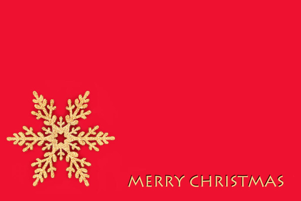 Καλά Χριστούγεννα χρυσό χρυσόσκονη νιφάδα δέντρο διακόσμηση σε κόκκινο φόντο. Ελάχιστο παραδοσιακό σχεδιαστικό σύμβολο για την εορταστική περίοδο των Χριστουγέννων. - Φωτογραφία, εικόνα