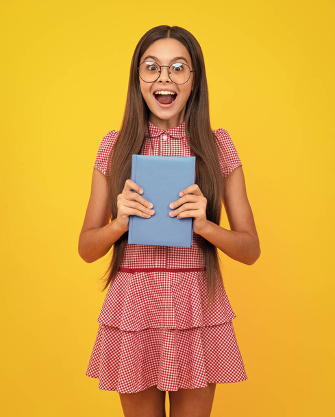 Amazed teen girl. Teenager school girl with books isolated studio background. Excited expression, cheerful and glad - Photo, Image