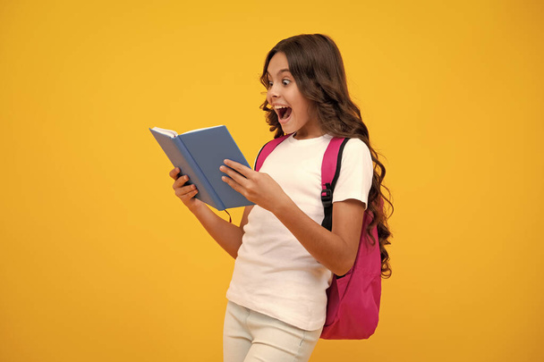 Erstaunte Teenie-Mädchen. Schuljugendliche Mädchen mit Schulrucksack halten Buch und Copybook in der Hand. Jugendlicher Student, isolierter Hintergrund. Lernen und Wissen. Gehen Sie studieren. Aufgeregter Ausdruck - Foto, Bild