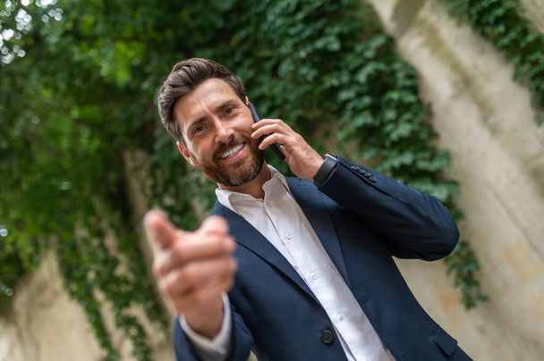 Phone call. Smiling young businessman talking on the phone - Fotó, kép