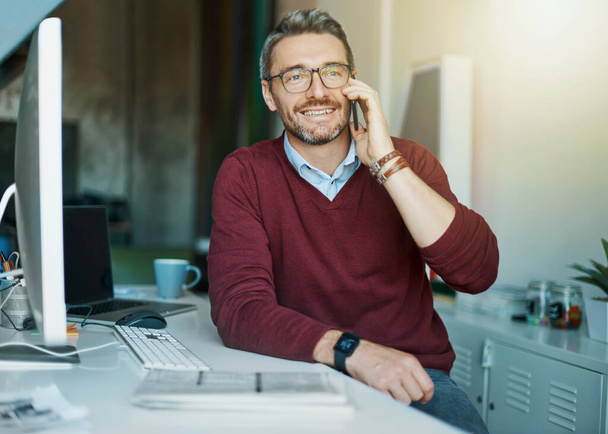 Müşterilerinin 100 'den fazla mutlu olmasını sağlamak. Yetişkin bir iş adamı ofiste çalışırken cep telefonuyla konuşur. - Fotoğraf, Görsel