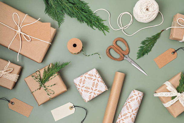 ギフトボックスと色のクラフト包装紙のロールを持つクリスマスの背景。クリスマスのお祝い、冬の休暇の準備。お祭りのモックアップ、トップビュー、フラットレイ - 写真・画像