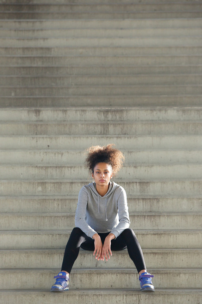 Aantrekkelijke jonge sport vrouw alleen zittend op stappen - Foto, afbeelding