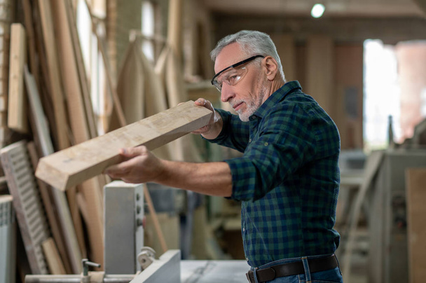 Carpentry. Carpenter working with wood in a workshop - Фото, зображення