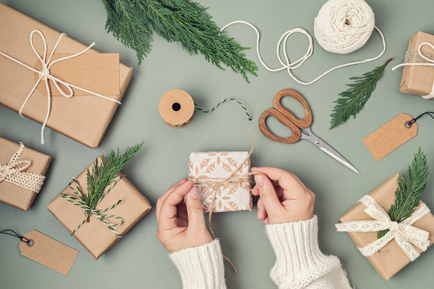 Χριστουγεννιάτικο φόντο με κουτιά δώρων και Kraft χαρτί περιτυλίγματος. Χριστούγεννα γιορτή, προετοιμασία για τις χειμερινές διακοπές. Εορταστική μακέτα, κορυφαία θέα, επίπεδο - Φωτογραφία, εικόνα