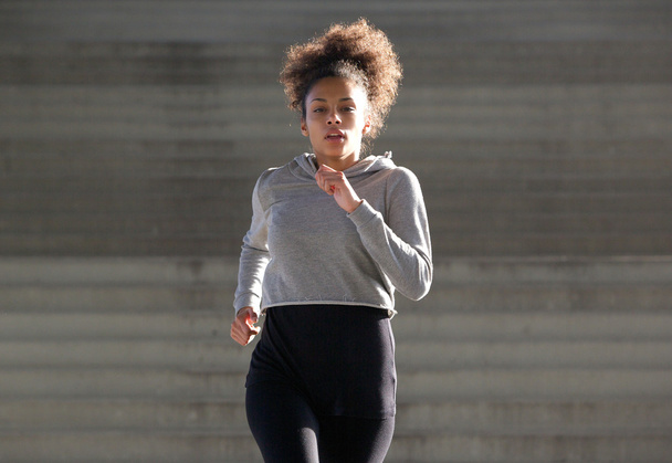 Σπορ νεαρή μαύρη γυναίκα που τρέχει σε εξωτερικούς χώρους  - Φωτογραφία, εικόνα
