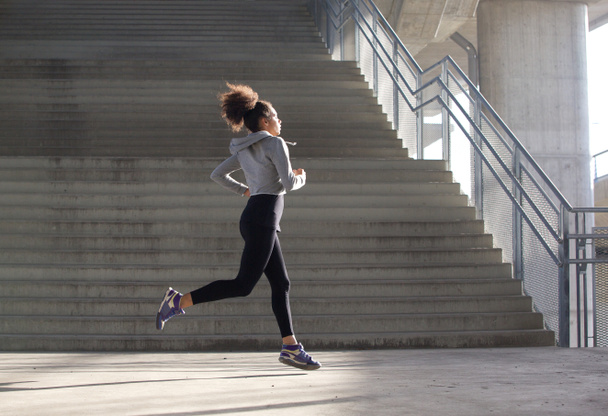 Jovem mulher saudável correndo em ambiente urbano
 - Foto, Imagem
