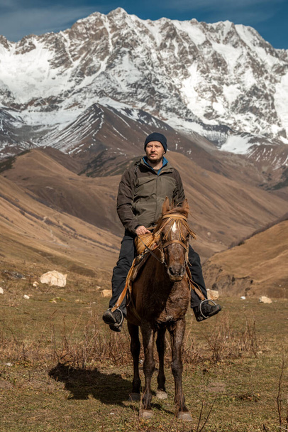 Paseos a caballo por las montañas nevadas de la región de Svanetia en Georgia. - Foto, imagen
