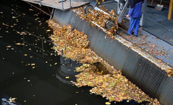 очистка воды на мельницу или на гидроэлектростанцию через сетку. листья и плавающие обломки, собранные машиной как грабли, не засорятся - Фото, изображение