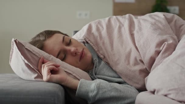 Chora biała kobieta śpiąca pod kołdrą. Nakręcony aparatem hel RED w rozdzielczości 8K.    - Materiał filmowy, wideo