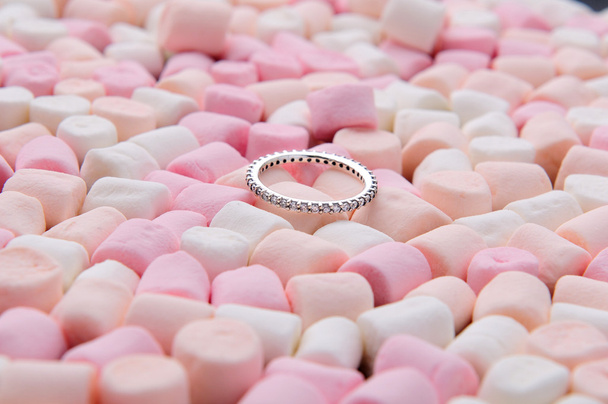 Wedding ring on pink and white mini marshmallows - Photo, Image