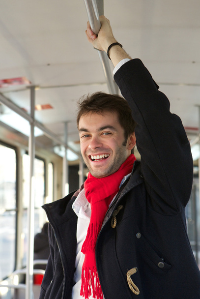 Smiling young man taking public transport - 写真・画像
