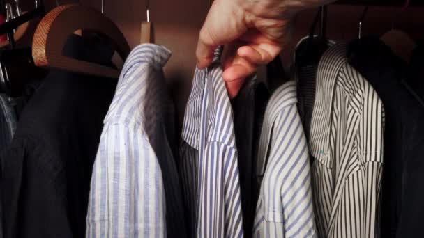 Ένας άντρας βγάζει ένα πουκάμισο από την ντουλάπα του. Υψηλής ποιότητας 4k πλάνα - Πλάνα, βίντεο