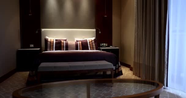 Moderne stijlvolle hotelkamer met groot bed en tafel. Avond slaapkamer interieur - Video