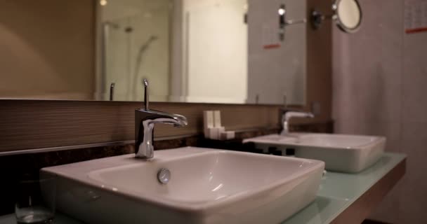 Cuarto de baño moderno lavabo con espejo en hermoso interior elegante. Dos lavabos y baño en habitación de hotel - Metraje, vídeo